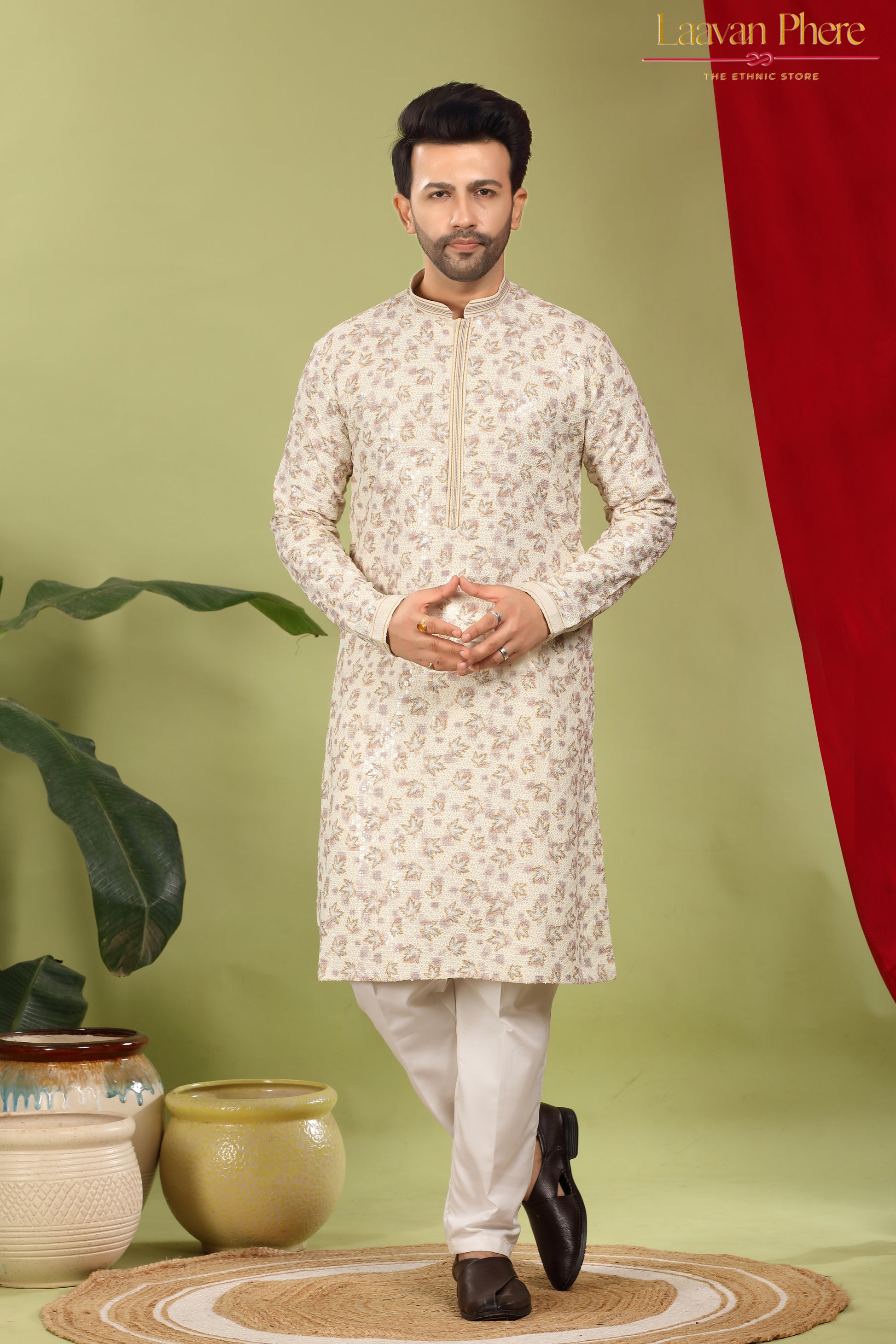 Man wearing a white kurta with a subtle pattern on a green background